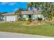 Well-maintained home featuring a stone facade garage, lush lawn, and mature palm trees in desirable area at 1104 76Th Nw St, Bradenton, FL 34209