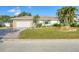 Well-maintained home featuring a stone facade garage, lush lawn, and mature palm trees in desirable area at 1104 76Th Nw St, Bradenton, FL 34209