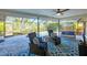 Enclosed lanai featuring blue brick flooring, ceiling fan, and relaxing seating area with pool view at 1104 76Th Nw St, Bradenton, FL 34209