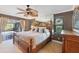 Well-lit main bedroom with a decorative ceiling fan, mirror wall, and balcony access at 1104 76Th Nw St, Bradenton, FL 34209