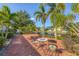 Charming brick patio with table and chairs overlooking serene canal and lush greenery at 1104 76Th Nw St, Bradenton, FL 34209