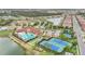Aerial view of community clubhouse and amenities including a pool, tennis courts, playground, and green space at 11959 Tapestry Ln, Venice, FL 34293