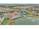 Picturesque aerial shot of the clubhouse, pool, tennis courts, and water feature in a planned community at 11959 Tapestry Ln, Venice, FL 34293