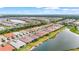 Wide aerial view of a community near a lake, showcasing many homes and serene surroundings at 11959 Tapestry Ln, Venice, FL 34293