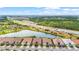 Aerial view showcasing a community with multiple homes, scenic ponds, lush greenery, and convenient highway access at 11959 Tapestry Ln, Venice, FL 34293