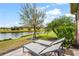 Scenic backyard overlooking a serene pond, complete with lush landscaping and lounge chairs at 11959 Tapestry Ln, Venice, FL 34293