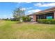 Spacious backyard showcasing a comfortable patio with lounge chairs and green lawn at 11959 Tapestry Ln, Venice, FL 34293