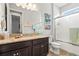 Bathroom featuring granite counters, dark wood cabinets, a shower, and tropical flamingo decor at 11959 Tapestry Ln, Venice, FL 34293