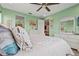 Spacious bedroom with a large bed, dresser, and mint green walls, offering a serene retreat at 11959 Tapestry Ln, Venice, FL 34293