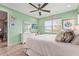 Bright bedroom with mint green walls, a large window, white dresser, and coastal themed artwork at 11959 Tapestry Ln, Venice, FL 34293
