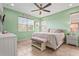 Comfortable bedroom with light green walls, tiled floors, and filled with natural light at 11959 Tapestry Ln, Venice, FL 34293