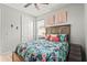 Comfortable bedroom with a tropical floral print bedspread and a window for natural light at 11959 Tapestry Ln, Venice, FL 34293
