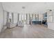Bright common area with seating area, bar with chairs, and luxury vinyl plank flooring throughout the space at 11959 Tapestry Ln, Venice, FL 34293