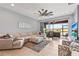 Spacious living room with neutral tones, lots of natural light, and access to the screened-in patio at 11959 Tapestry Ln, Venice, FL 34293