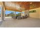 Spacious covered patio with stone fireplace, comfortable seating, and scenic views of lush landscaping at 11959 Tapestry Ln, Venice, FL 34293