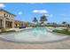 Community pool offers zero entry, palm trees, umbrellas, and seating for relaxing poolside at 11959 Tapestry Ln, Venice, FL 34293