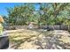 Expansive fenced backyard with mature trees, a storage shed, and ample space for outdoor activities at 1417 14Th E St, Bradenton, FL 34208