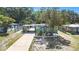 A charming single-story home features a concrete driveway, carport, mature trees, and a beautifully landscaped front yard at 1417 14Th E St, Bradenton, FL 34208