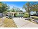 Single-story home featuring a long driveway, a carport, and a beautifully landscaped front yard with mature trees at 1417 14Th E St, Bradenton, FL 34208