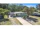 Quaint home with a light-green and white exterior, featuring a convenient carport, mature trees and long driveway at 1417 14Th E St, Bradenton, FL 34208