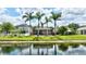 Lush backyard with pond view, screened-in lanai, and palm trees providing a private and tropical oasis at 14315 Tree Swallow Way, Lakewood Ranch, FL 34202