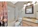 Updated bathroom featuring granite counters, wood cabinets, and tiled shower and tub at 14315 Tree Swallow Way, Lakewood Ranch, FL 34202