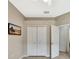 Neutral bedroom with tv, wood-look flooring, a closet, and access to the bathroom at 14315 Tree Swallow Way, Lakewood Ranch, FL 34202