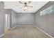 Neutral bedroom featuring light-colored floors, a ceiling fan, and a window with natural light at 14315 Tree Swallow Way, Lakewood Ranch, FL 34202