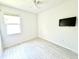 Cozy bedroom with light colored floor, a mounted television, and ample natural light at 14315 Tree Swallow Way, Lakewood Ranch, FL 34202