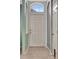 Bright entryway featuring neutral walls, light wood-look flooring, and a transom window above the front door at 14315 Tree Swallow Way, Lakewood Ranch, FL 34202