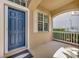 Charming covered front porch with a classic blue door, window with shutters, and a cozy, inviting entrance at 14315 Tree Swallow Way, Lakewood Ranch, FL 34202