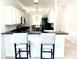 Open kitchen area with black appliances, bar seating and views to the breakfast nook at 14315 Tree Swallow Way, Lakewood Ranch, FL 34202