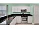 Stylish kitchen featuring white cabinetry, stainless steel appliances, and granite countertops, perfect for cooking and entertaining at 14315 Tree Swallow Way, Lakewood Ranch, FL 34202