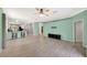 Open-concept living room flowing into the kitchen, featuring neutral walls, a ceiling fan, and light floors at 14315 Tree Swallow Way, Lakewood Ranch, FL 34202