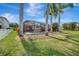 A screened-in pool surrounded by lush landscaping and tall palm trees offers a private outdoor oasis at 14315 Tree Swallow Way, Lakewood Ranch, FL 34202