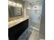 Modern bathroom featuring a glass-enclosed shower, granite countertop, and sleek, dark wood cabinets at 1500 State St # 401, Sarasota, FL 34236