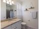 Bright bathroom featuring granite countertops, modern fixtures, and minimalist decorative shelving at 17418 Blue Ridge Pl, Lakewood Ranch, FL 34211