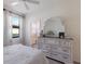 Light bedroom with a dresser, a bed with soft, white linens and an adjoining bathroom at 17418 Blue Ridge Pl, Lakewood Ranch, FL 34211