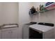 Functional laundry room with sink, modern Samsung washer/dryer, and storage shelving for added convenience at 17418 Blue Ridge Pl, Lakewood Ranch, FL 34211