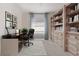 Well-lit home office with built-in bookshelves, a comfortable desk, and a view of the outdoors at 17418 Blue Ridge Pl, Lakewood Ranch, FL 34211