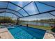 A luxurious in-ground pool and spa with lake views, a fountain, and an outdoor seating area within a screened enclosure at 17418 Blue Ridge Pl, Lakewood Ranch, FL 34211