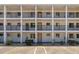 Three-story white condo building featuring private balconies with black railings and reserved parking spaces at 2008 Canal Dr # M3, Bradenton, FL 34207