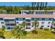 Aerial view of condos with large windows, balconies, palm trees, and well-maintained green lawn at 2008 Canal Dr # M3, Bradenton, FL 34207