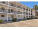 Condo building with white facade, black railings, balconies, and palm trees providing a tropical feel at 2008 Canal Dr # M3, Bradenton, FL 34207