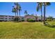 Exterior lawn view of condo building with manicured lawns and mature palm trees at 2008 Canal Dr # M3, Bradenton, FL 34207