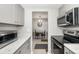 Galley kitchen with stainless appliances and white cabinets, adjacent to small dining area at 2008 Canal Dr # M3, Bradenton, FL 34207