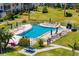 Community pool with lounge chairs, picnic tables, palm trees, and lush green landscape at 2008 Canal Dr # M3, Bradenton, FL 34207