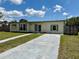 Charming single-story home featuring a well-maintained lawn and a long concrete driveway under a sunny sky at 22343 Lasalle Rd, Port Charlotte, FL 33952