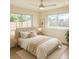 Serene main bedroom featuring neutral tones, tiled floors, ceiling fan and two bright sunny windows at 22343 Lasalle Rd, Port Charlotte, FL 33952