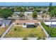 Aerial shot of a fenced-in backyard with a screened patio, lush green grass, and surrounding neighborhood views at 248 Venice East Blvd, Venice, FL 34293